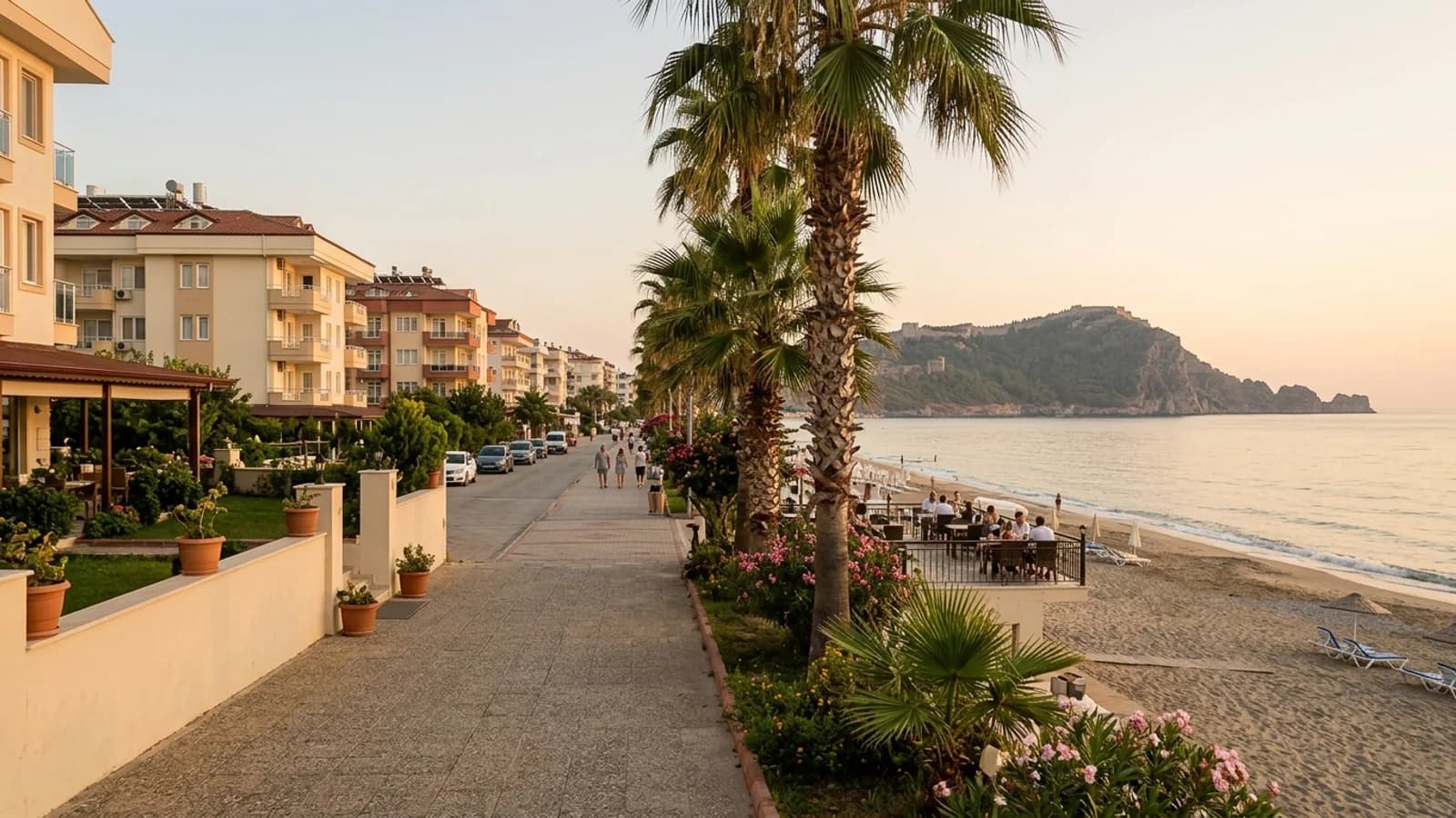 Met palmen omzoomde boulevard en strand in Oba, met het kasteelschiereiland van Alanya in de verte.