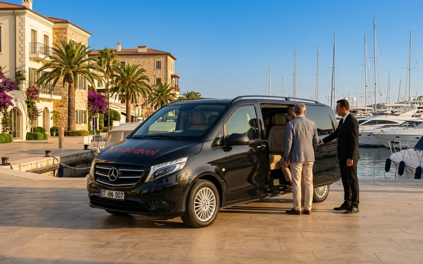 Couple stepping into the black Hana Travel VIP Vito on a sunny marina promenade with white yachts — Antalya VIP transfer