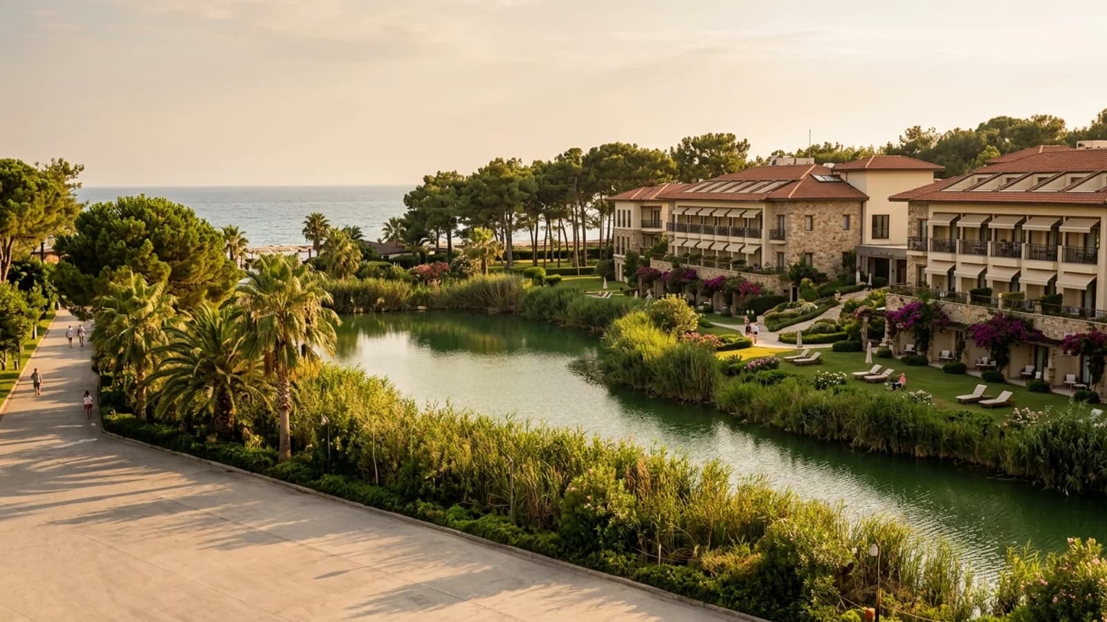Lakeside resort hotels in Titreyengöl Resort hotels at Titreyengöl stand beside a small green lake with reeds and palm trees.